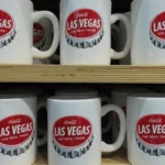 This is a picture of a shelf of Coca-Cola Mugs at Coca-Cola World store in Las Vegas