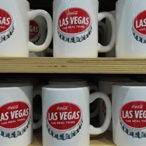 This is a picture of a shelf of Coca-Cola Mugs at Coca-Cola World store in Las Vegas