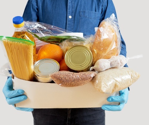 This is a picture of a man holding a box of food and pantry items at a food bank in Las Vegas Nevada